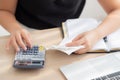 Closeup hand woman calculating expenses household and writing notebook on desk, girl checking bill and stress and note Royalty Free Stock Photo