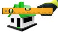 Gloved Hand Holding a Spirit Level with a Model House on Background
