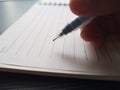 Closeup hand writing with pen on blank notebook. Stock photo. Download image Royalty Free Stock Photo