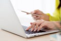 Closeup hand of young asian businesswoman working on laptop computer on desk at home office. Royalty Free Stock Photo