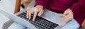 Closeup hand of young asian woman online shopping in Christmas with credit card on laptop computer.