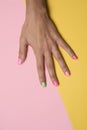 Woman hand with her nails painted pink and green