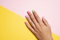 Woman hand with her nails painted pink and green