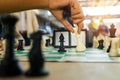 Closeup of a hand of a young Latino removing a rival& x27;s piece from a chessboard