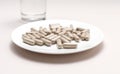 Closeup Handful Of Pills, Capsules OF Slippery Elm And Glass Of Water. Dietary Nutritional