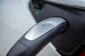 Closeup of the handle to an electric charger plugged into a Tesla