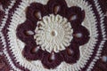 Closeup of handmade maroon and white crochet pillow