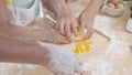 Closeup hands of African American family with daughter add egg to flour and thresh for cooking with father and mother together.