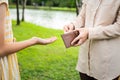 Closeup hands of asian woman hands open wallet,mother or guardian giving pocket money to daughter in green nature background,child Royalty Free Stock Photo