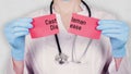 Closeup, hands in blue medical gloves hold and tear red paper card with an inscription Castleman Disease. doctor dressed