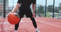 Closeup hands bouncing basketball ball. Man is practicing exersice hitting basketball ball training on court in city Royalty Free Stock Photo