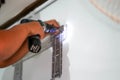 Closeup hands of builder holding an electric drill is drilling a hole in the wall for install air condition at construction site