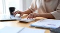 Businesswoman working with laptop computer and using a calculator at office desk. Royalty Free Stock Photo