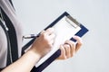 Closeup of Hands of Caucasain Woman Writing on Paper Sheet on Notepad