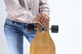 Closeup of hands of Caucasian Girl in Pink Hoodie Holding Longboard