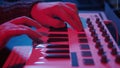 Hands using midi keyboard in home studio in night with neon lights Royalty Free Stock Photo