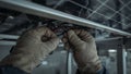 Closeup of hands connecting wires under a solar panel, technician wearing protective gloves Royalty Free Stock Photo