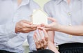 Closeup hands of an couple students holding a little house together, Concept of sustaining a house between two people.