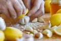 closeup of hands crushing garlic with lemon and honey preparations beside Royalty Free Stock Photo