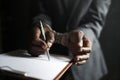 Closeup of hands cuffed forced to sign paper