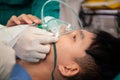 Closeup hands of doctor and assistant holding oxygen mask with patient emergency in the operation room.