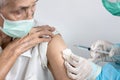 Closeup,Hands of doctor giving Coronavirus vaccine with syringe injection in shoulder of old elderly for prevention COVID-19,asian