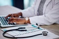 Closeup, hands and doctor with a laptop, stethoscope and typing with connection, documents and telehealth. Black woman Royalty Free Stock Photo