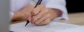 Closeup hands of doctor woman signing on document paper at clinic. Royalty Free Stock Photo