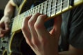 closeup on hands fingering guitar fretboard