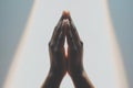 closeup of hands folded in prayer in a ray of light Royalty Free Stock Photo