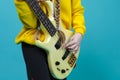 Closeup of hands of Guitar Musician Playing On Yellow Bass Guitar Posing In Fashionable Yellow Hoody Jacket With Instrument Over Royalty Free Stock Photo