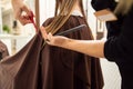 Closeup of hands of hairdresser cutting long blond hair in hair salon Royalty Free Stock Photo