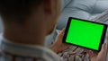 Closeup hands holding chroma key tablet. Unknown man typing green screen at home