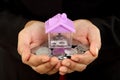 Closeup of hands holding coins and house shape Royalty Free Stock Photo