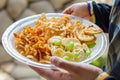 closeup of hands holding a disposable plastic plate with party snacks Royalty Free Stock Photo