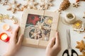 Closeup of hands holding a festive box with Christmas cookies