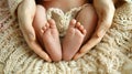 Closeup of hands holding a newborn baby& x27;s feet in the shape of a heart, symbolizing love and car Royalty Free Stock Photo