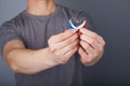 Closeup of hands holding small inconspicuous hearing aids in heart shape Royalty Free Stock Photo