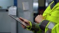 Closeup hands holding tablet computer at modern huge special facility storage.