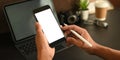 Closeup hands are holding a white blank screen smartphone and stylus pen at the black working desk Royalty Free Stock Photo