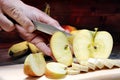 Closeup of hands with a knife cut into slices a ripe apple. Royalty Free Stock Photo