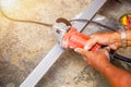 Closeup hands of laborer holding electric angle grinder working cutting aluminum Royalty Free Stock Photo