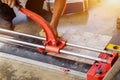 Closeup hands of laborer using cutting tile machine at construction site