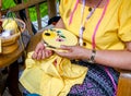 Hands of ladies are demonstrating sewing and decorating of clothes by embroidery frame for students in housework class