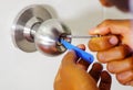 Closeup hands of locksmith using pick tools to open locked door Royalty Free Stock Photo