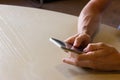 Closeup on hands of man using cellphone on table Royalty Free Stock Photo
