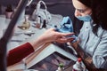 Closeup hands. Manicure procedure in progress - Beautician master applying color nail polish. Royalty Free Stock Photo