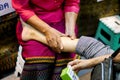 Hands of massager lady are demonstration touch and massage a tourists leg in Thailand culture fair