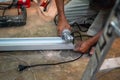 Closeup hands of the master saw the metal holding electric angle grinder working cutting aluminum lumber at construction site Royalty Free Stock Photo