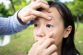 Closeup of hands mother checking little child girl patient sore eyes,daughter feeling eyes pain,woman examining eyes of asian